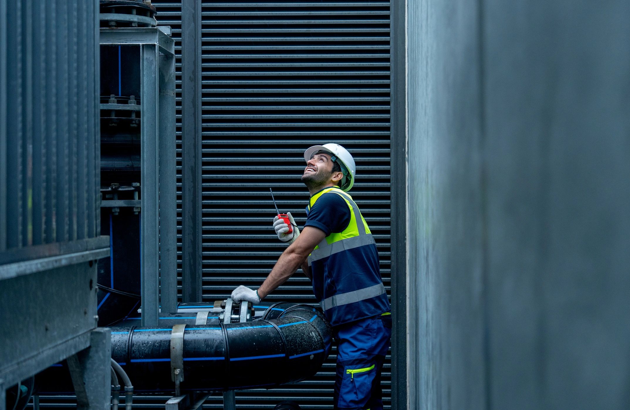 Engineer inspecting commercial pipework in a plant room